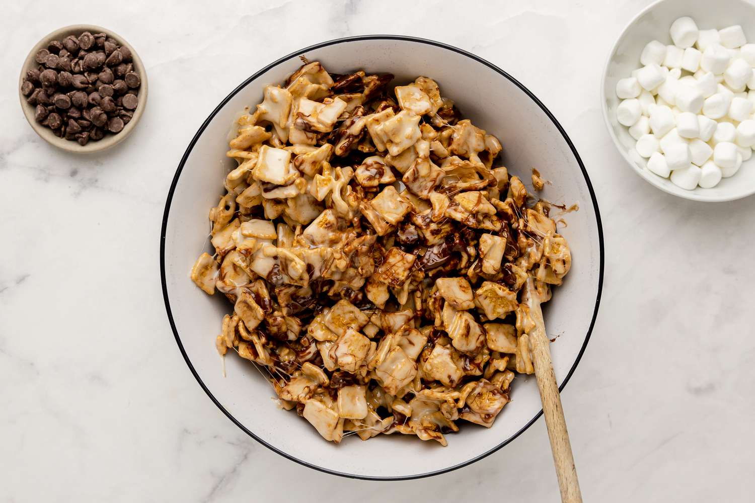Cereal and Chocolate Chips in Big Bowl with Melted Marshmallows for S’Mores Bars, and Two Small Bowls with Chocolate Chips and Marshmallows Situated Next to Big Bowl