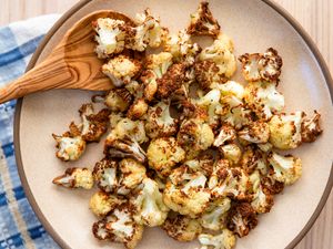 Garlicky Air Fryer Cauliflower on a plate with a wooden spoon