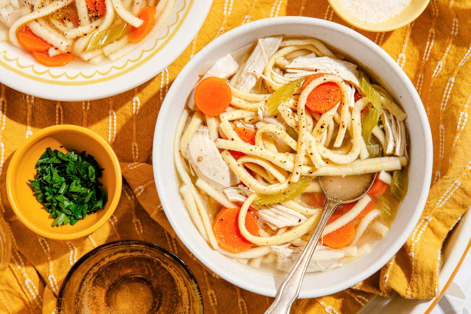 Bowl of chicken noodle soup at a table setting