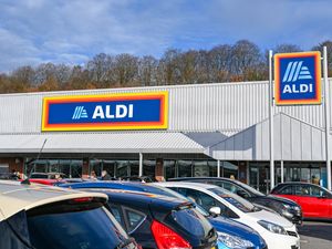 An Aldi supermarket storefront with a parking lot in the foreground