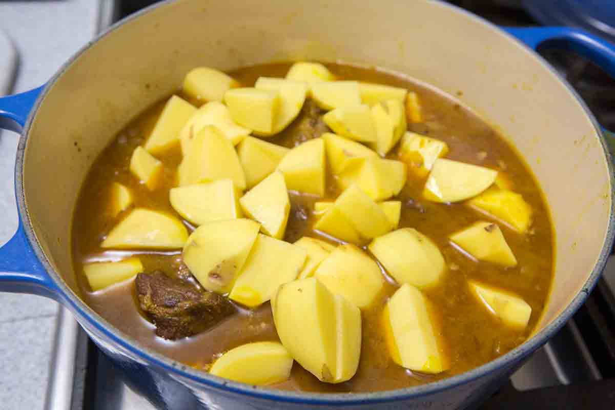 potatoes added to lamb curry in pot