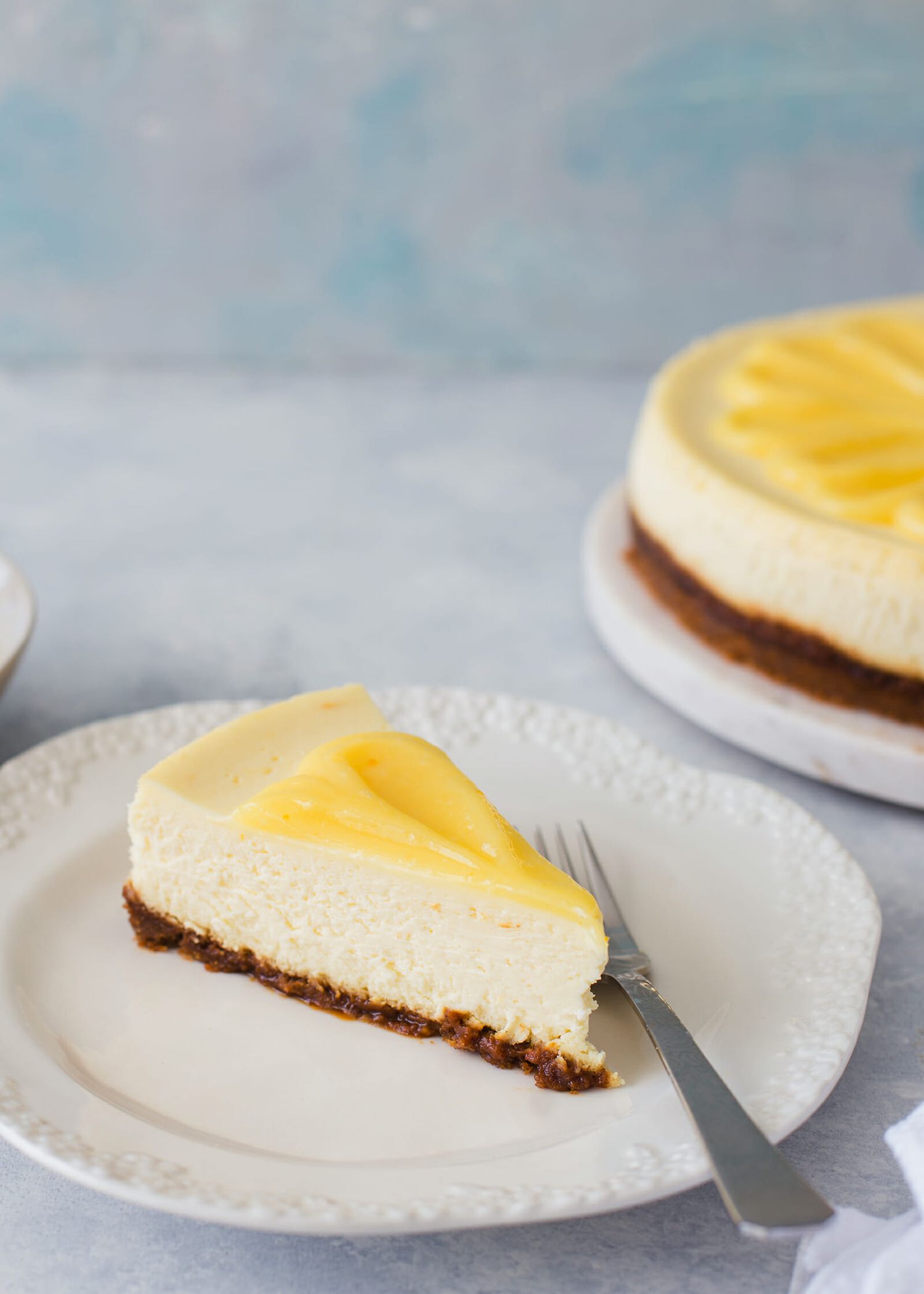 Slice of lemon cheesecake on white a plate with a fork