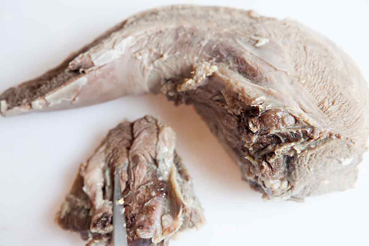 cut out rough patch of beef tongue for making tongue tacos
