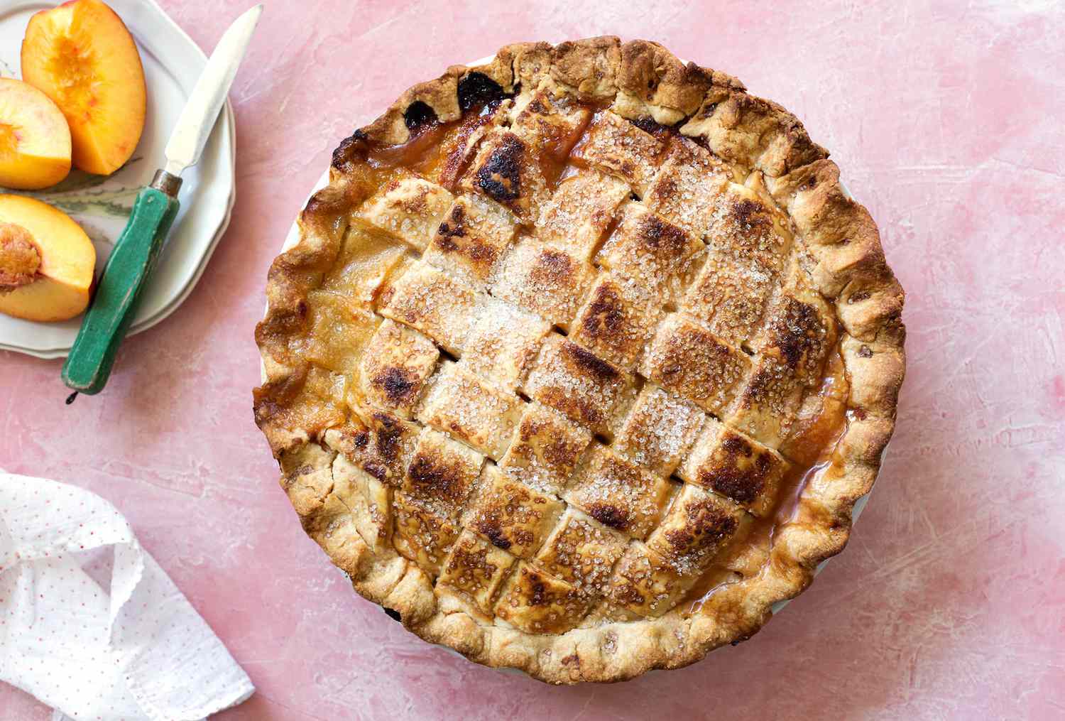 Peach Pie with a lattice crust on a pink background