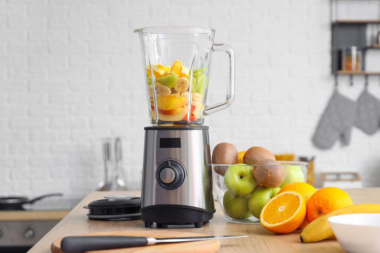 A blender with fresh fruit on a kitchen table