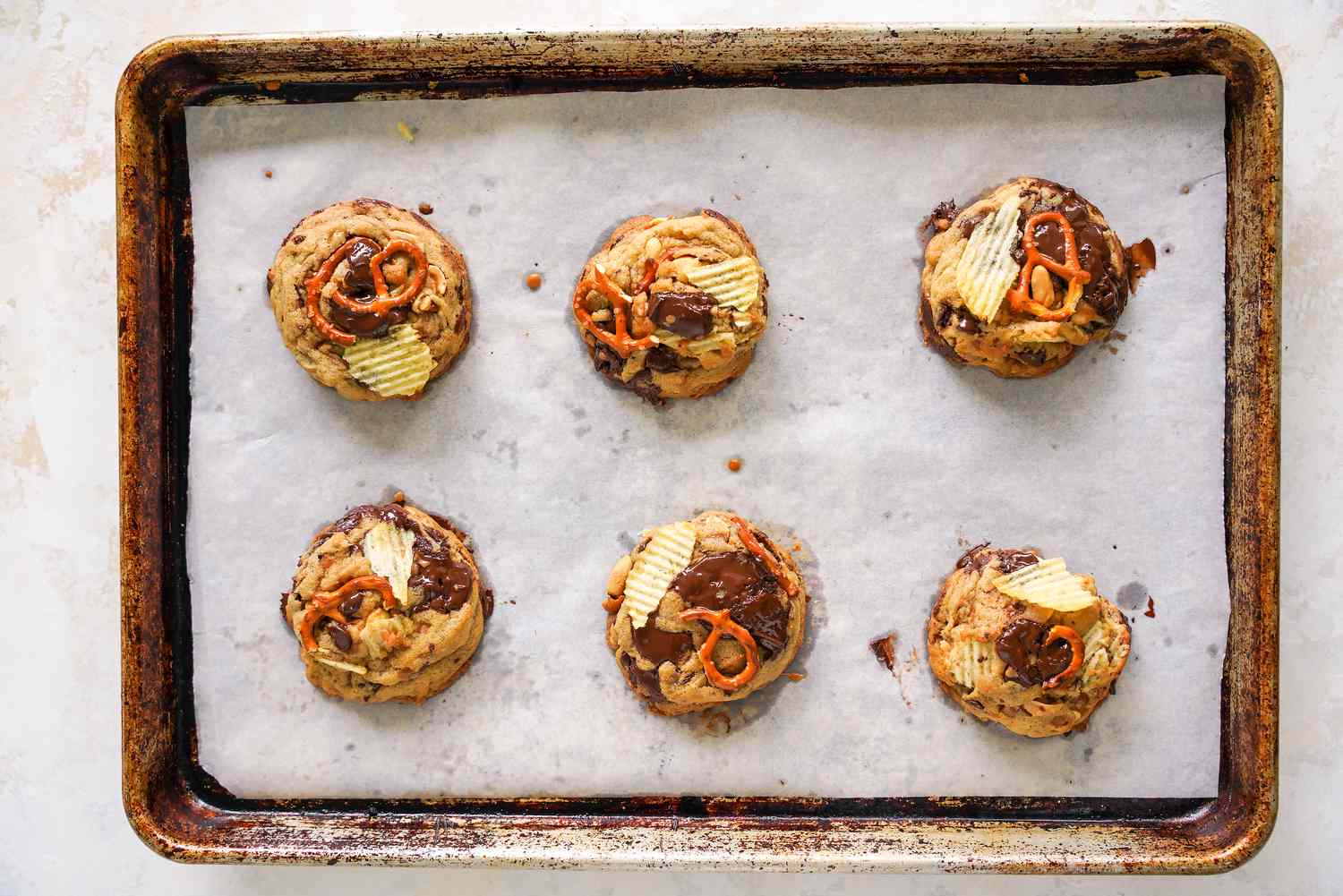 Baked Kitchen Sink Cookies on a Parchment Paper Lined Baking Sheet