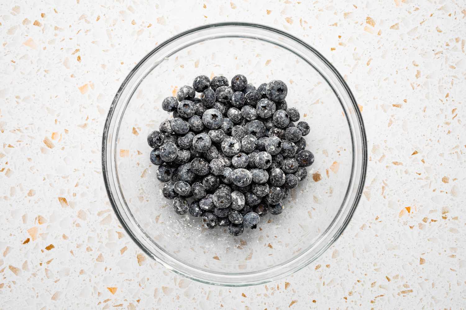 Blueberries Mixed with Remaining Flour in a Bowl for Muffin Tops Recipe