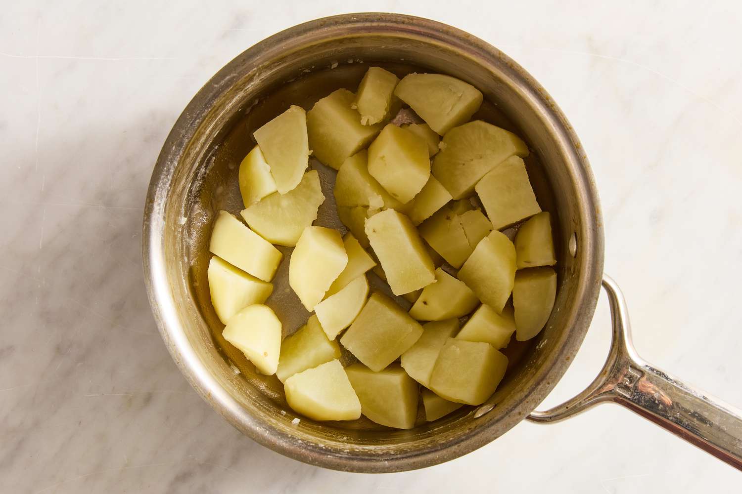 Overhead view of a pot of boiled cubed potatoes from Boxty (Irish Potato Pancakes) recipe
