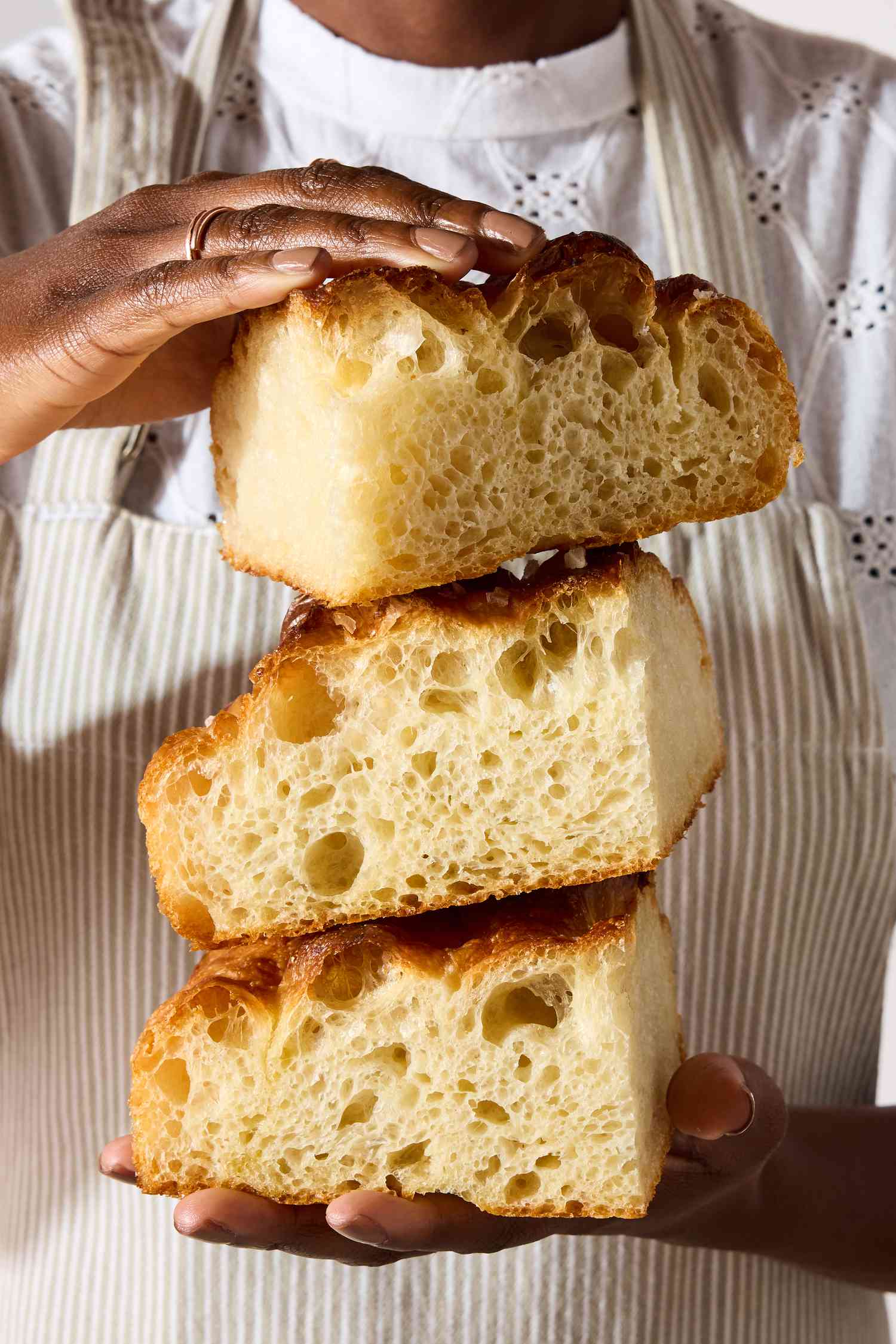 hands holding cut pieces of King Arthur Flour’s Big and Bubbly Focaccia