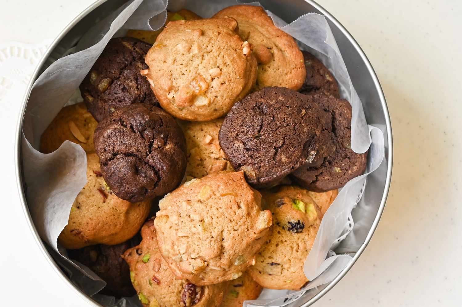 An assortment of cookies in a round tin box