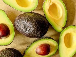 An assortment of avocados halved, some with pits and some without