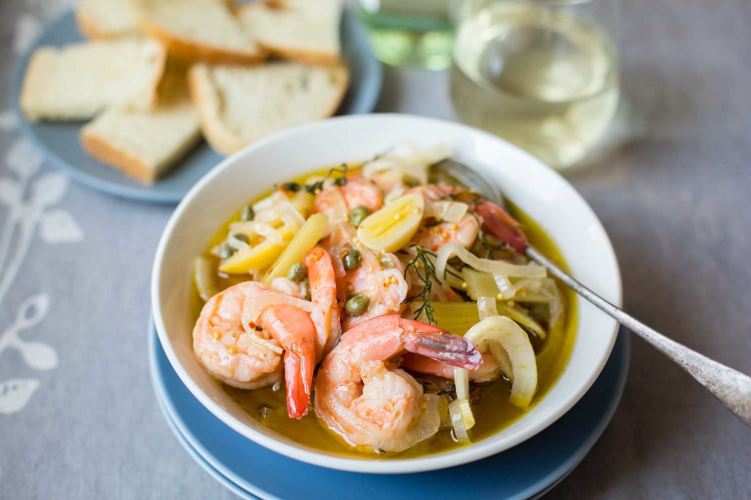 Bowl of Pickled Shrimp with Bread and Glasses of Wine in Background