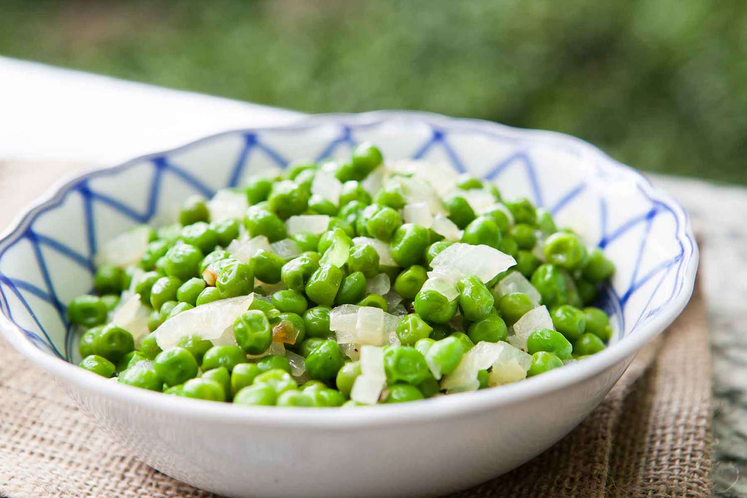A bowl of peas and onions, ready to serve and eat.