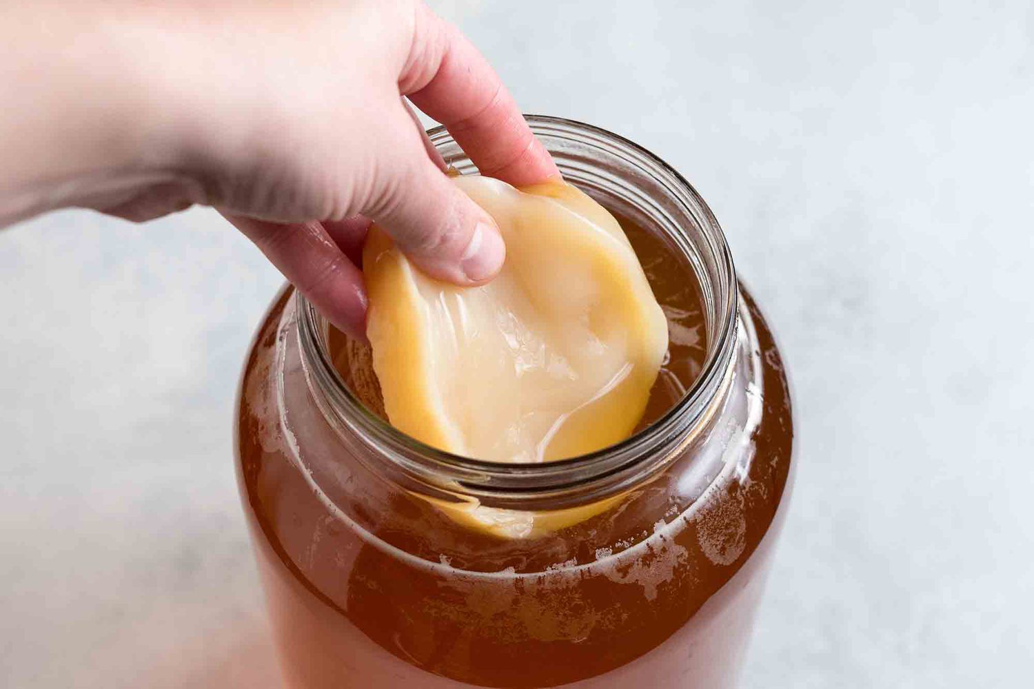 Add the scoby for homemade kombucha to the jar with the sweet tea and prepared kombucha
