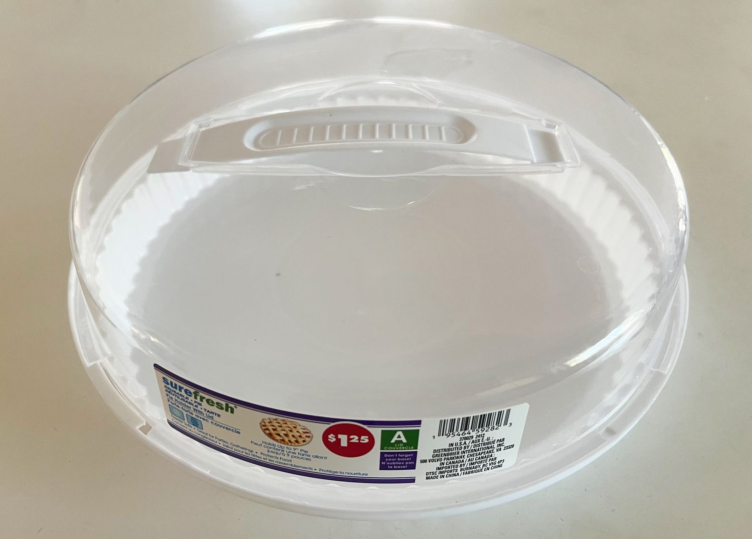 Plastic pie container with lid and handle, labeled with a price tag of $1.25 and product information sticker