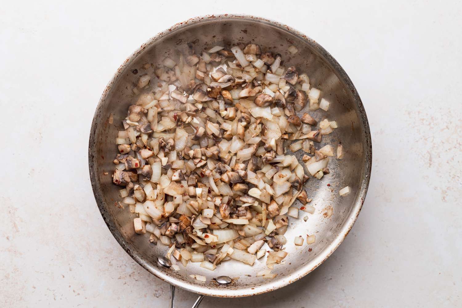 Mushrooms and onions in a pan for baked spaghetti sauce 