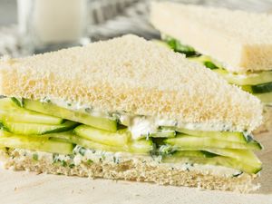 Cucumber sandwiches on a plate, featuring layers of cucumber and a white bread base