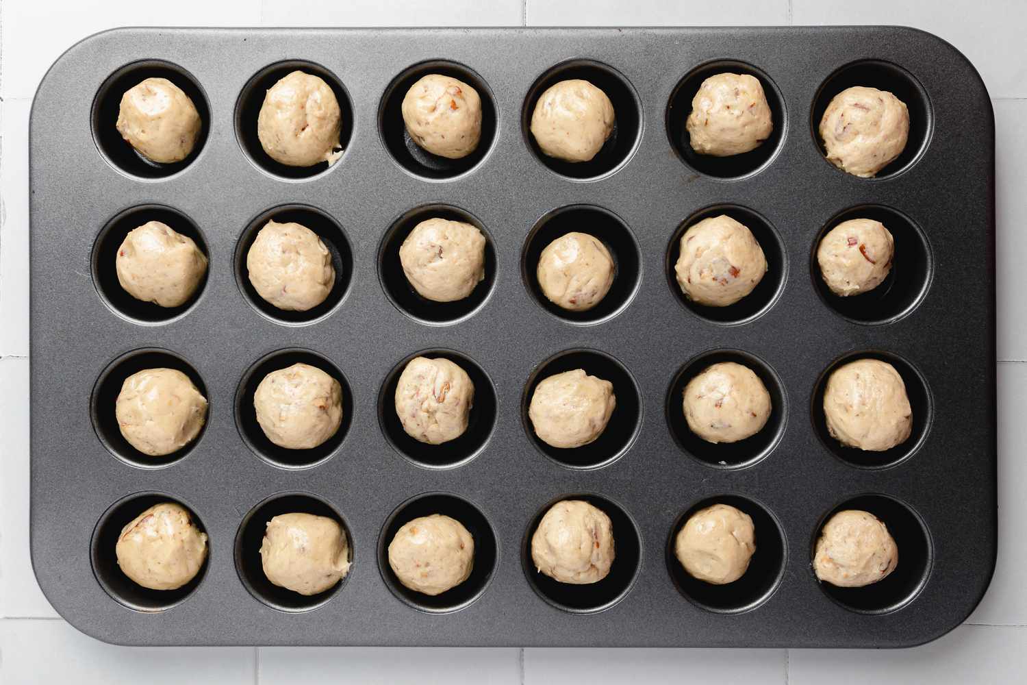 Turtle Cookie Cup Dough Rolled into Small Balls and Placed in Cookie Tray Cavities