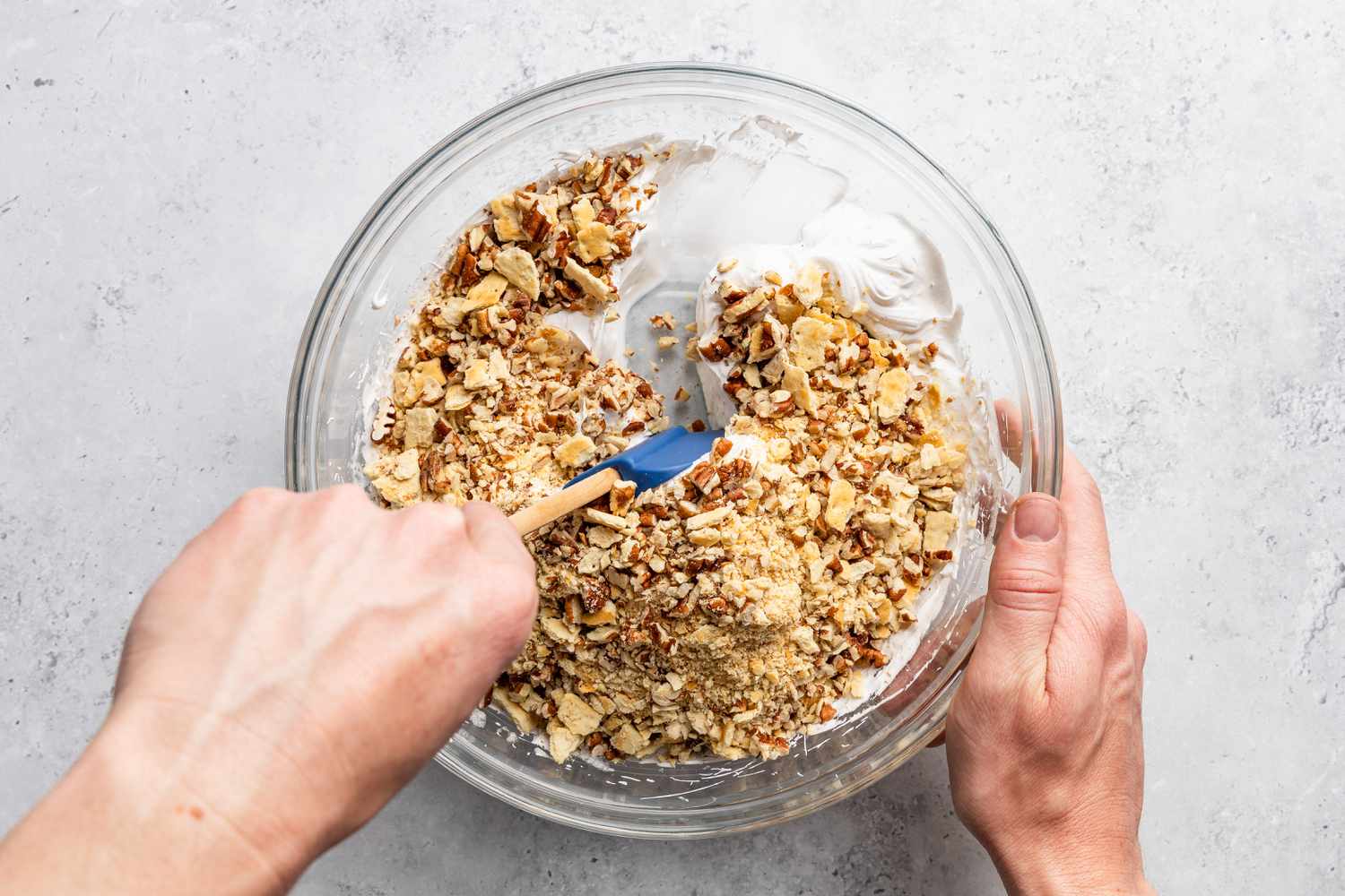 whipped egg whites, pecans, and crushed saltine crackers folded together in a bowl for soda cracker pie recipe