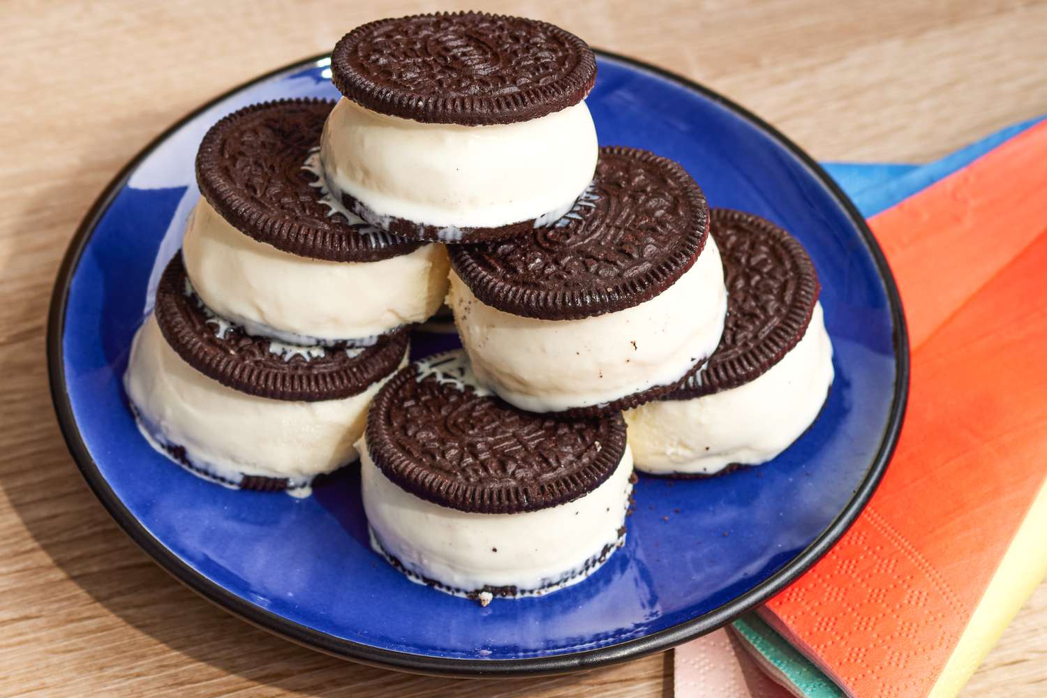 2-Ingredient Oreo Ice Cream Sandwiches Stacked on a Plate Next to Colorful Single Use Napkins