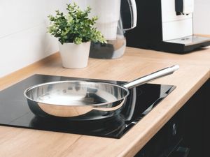 A stainless steel frying pan on an electric stovetop