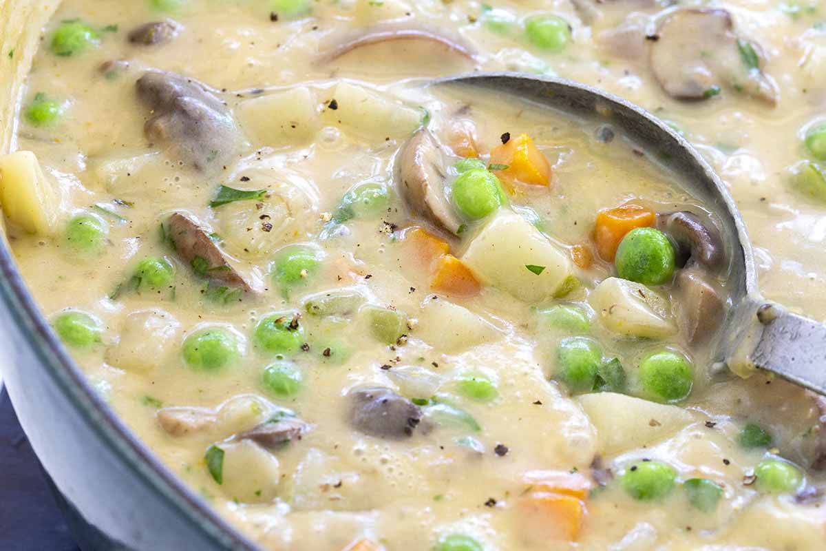 Easy vegetable pot pie filling of mushrooms, potatoes, carrots and celery cooked in a skillet with heavy cream and peas.