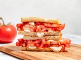 tomato sandwich (cut in half and stacked) on a cutting board