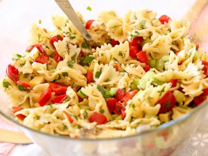 Bowl of pasta salad with mixed vegetables and herbs