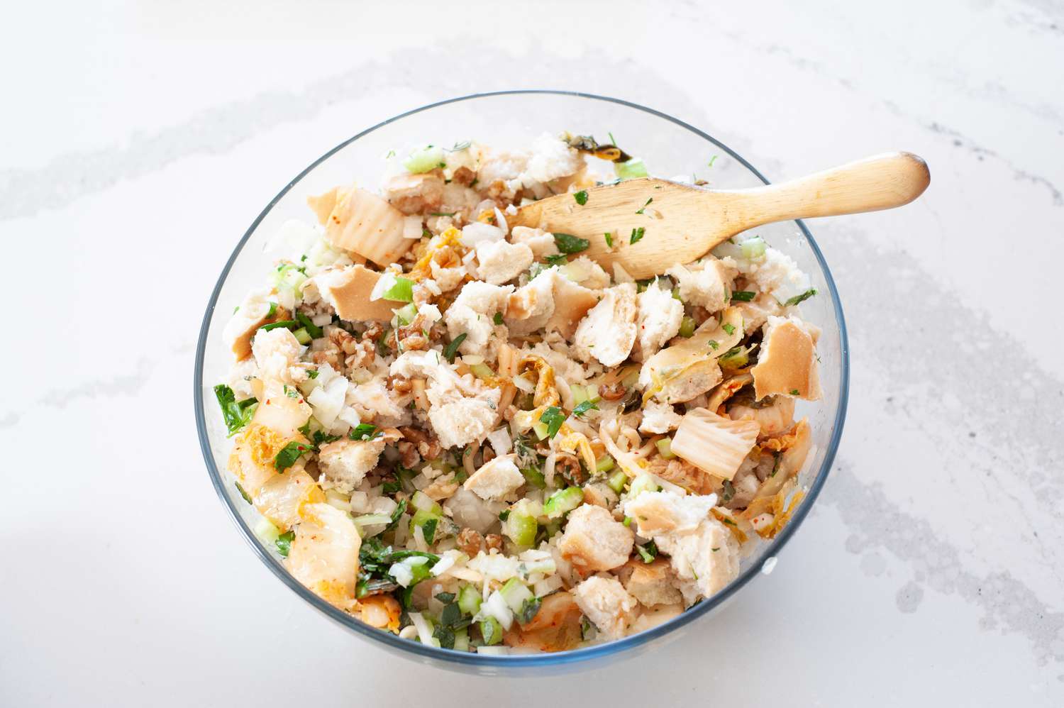 Ingredients to make a stuffing recipe in a glass bowl.