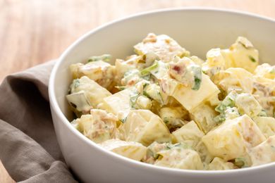 Side view of homemade potato salad in a white bowl.