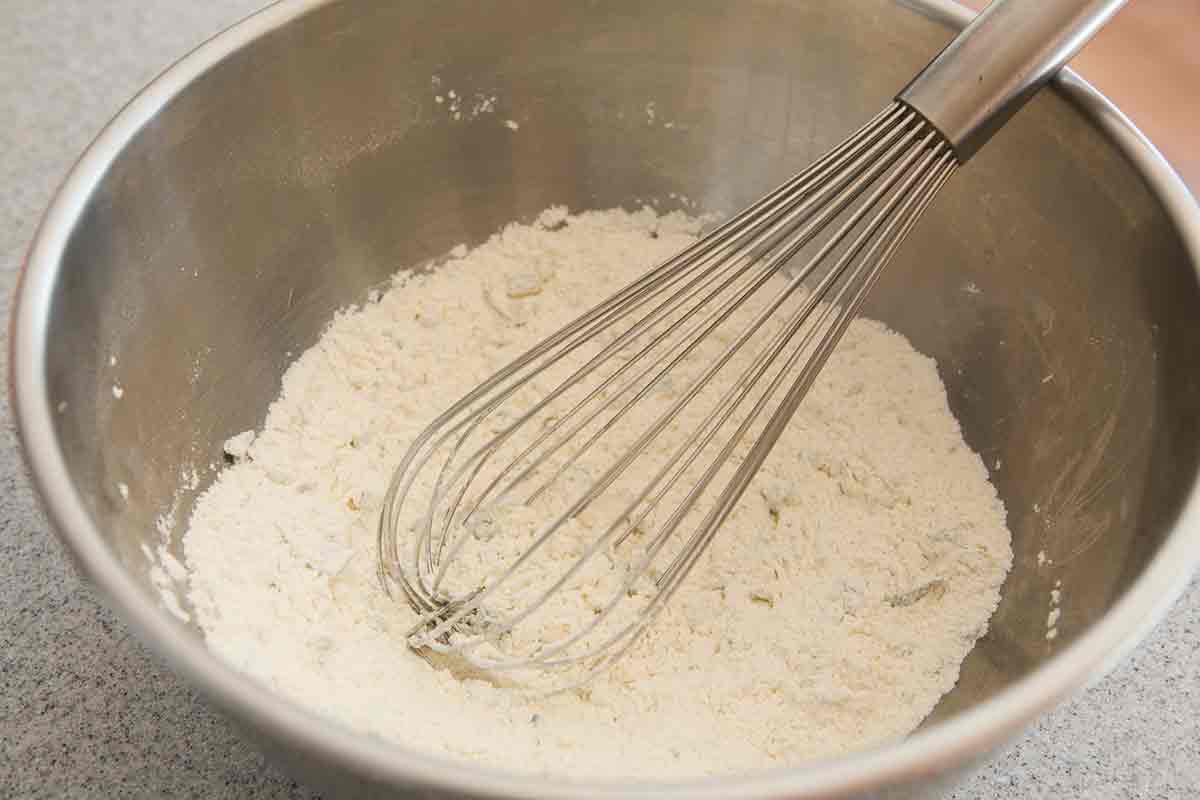 Homemade dumplings whisked in a metal bowl.