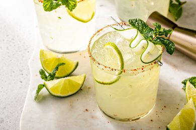 Cucumber margarita with lime and spicy rim, garnished with sliced cucumber and mint