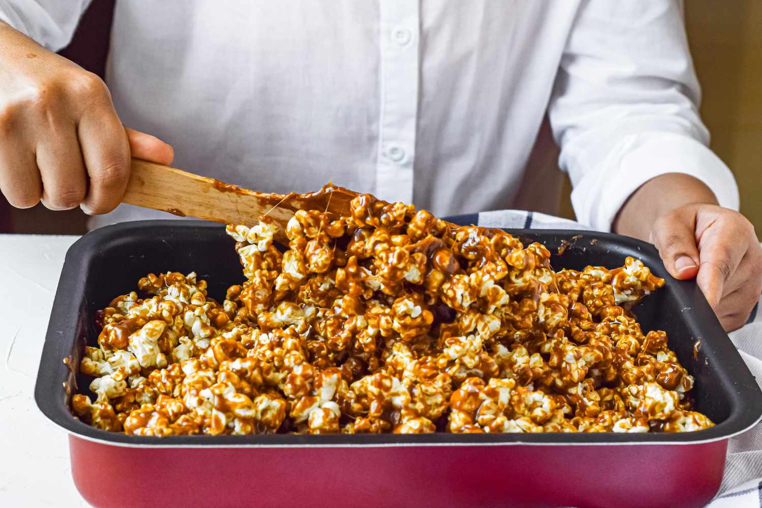 Mixing Caramel Corn in Pan Using Wooden Spoon 