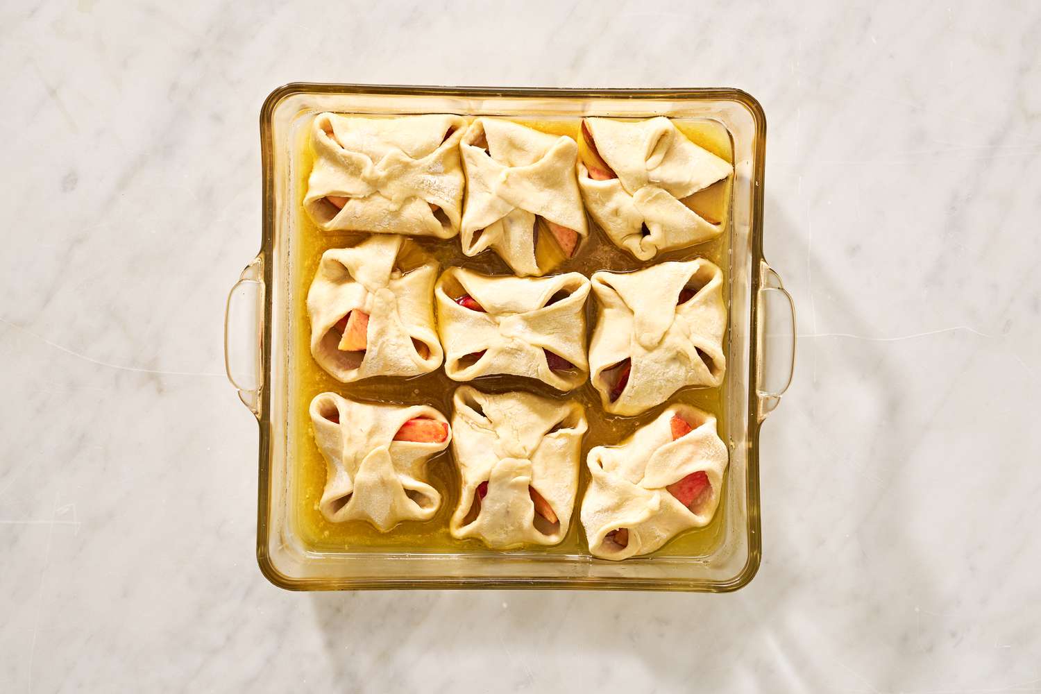Unbaked peach dumplings in a pan