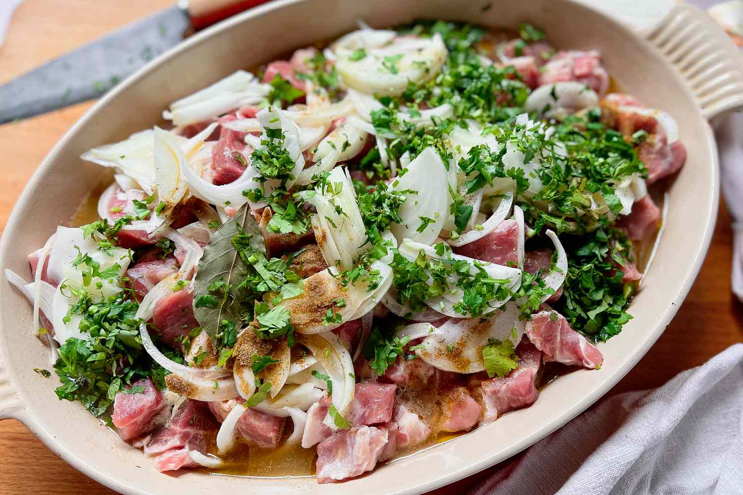 Carnitas Ingredients (Cubed Pork Shoulder, Onions, Cilantro, and Seasoning) in a Casserole Dish