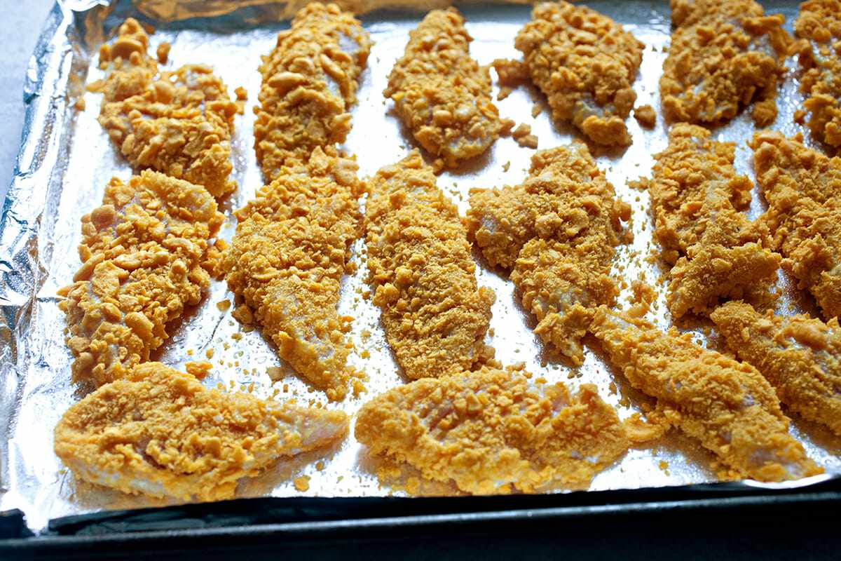 A foil-lined baking sheet of Goldfish chicken tenders