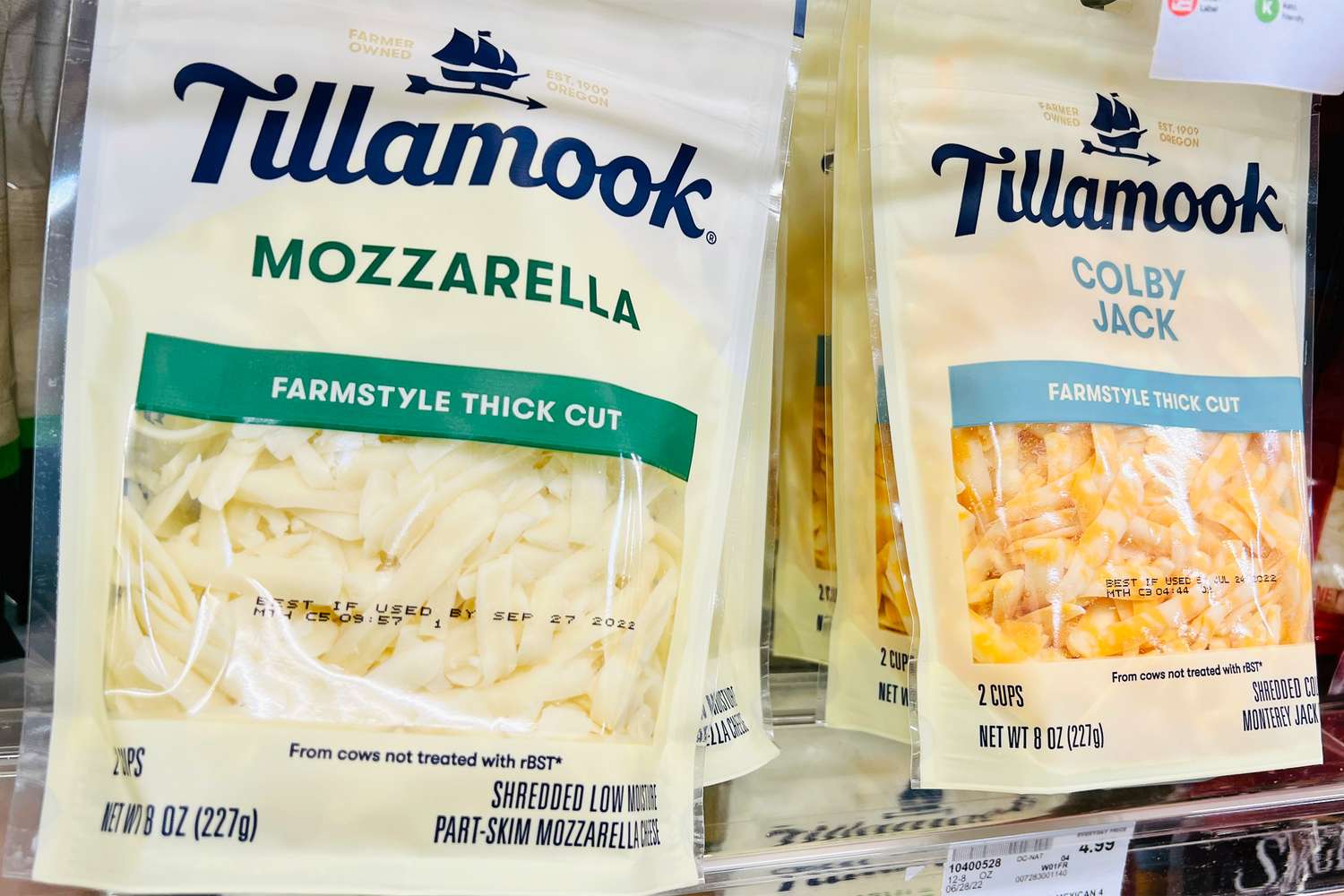 Packages of Tillamook shredded mozzarella and Colby Jack cheese on a store shelf