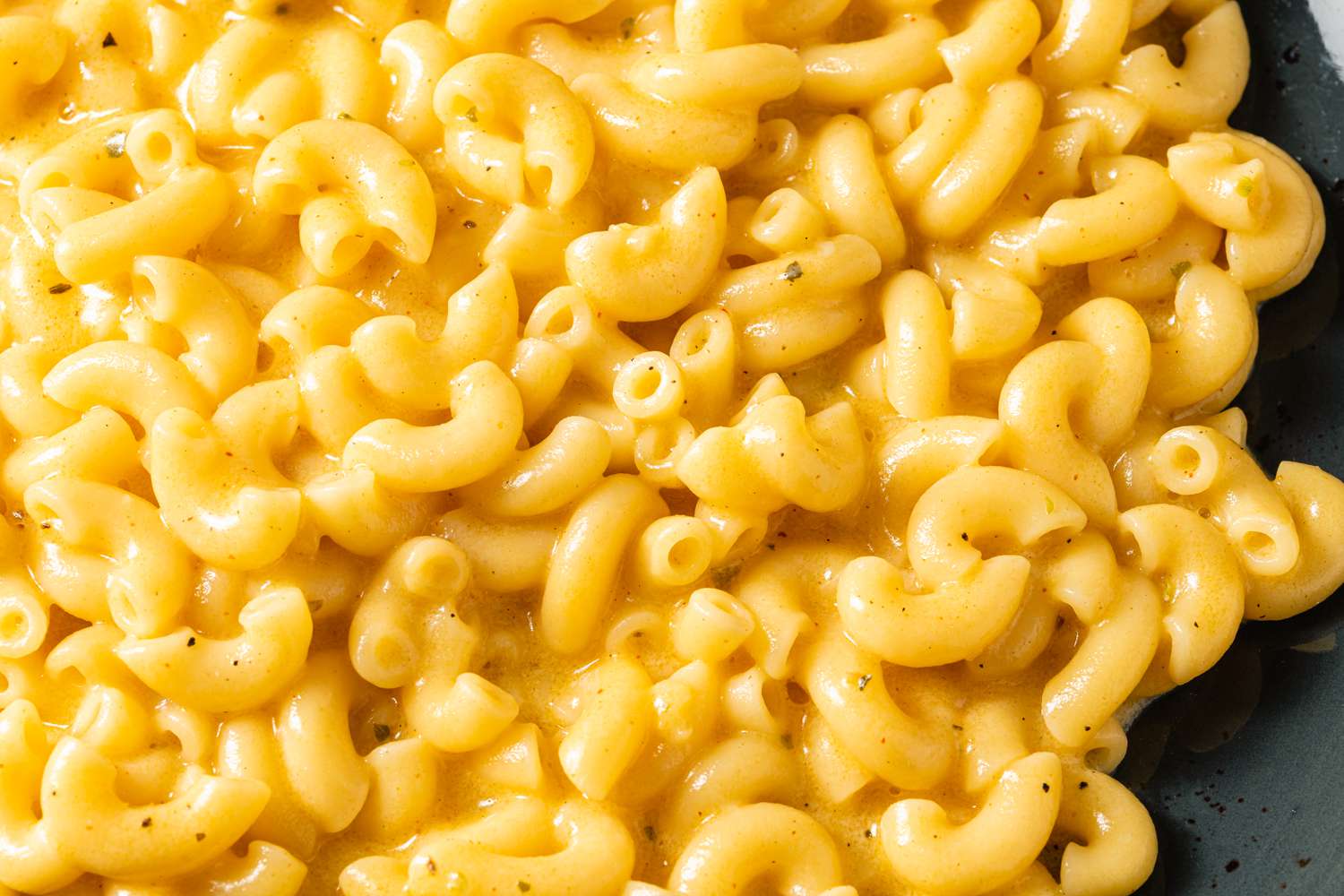 Close up of mac and cheese on a black porcelain plate