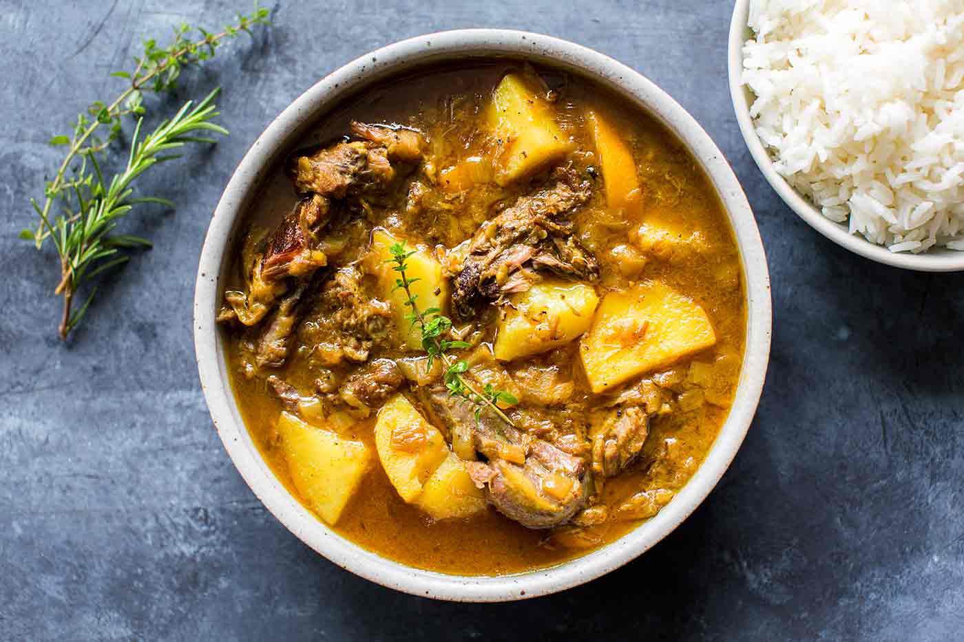 Lamb Curry in bowl with a bowl of rice on the side