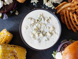 Blue Cheese Wing Dip - sauce in bowl surrounded by burgers and sides
