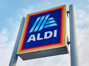 The ALDI store sign against a cloudy sky