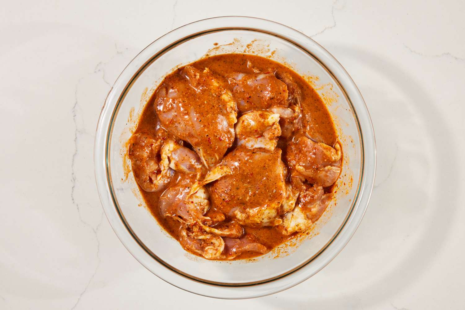 Chicken thighs marinating in a bowl of marinade for copycat Chipotle chicken recipe 