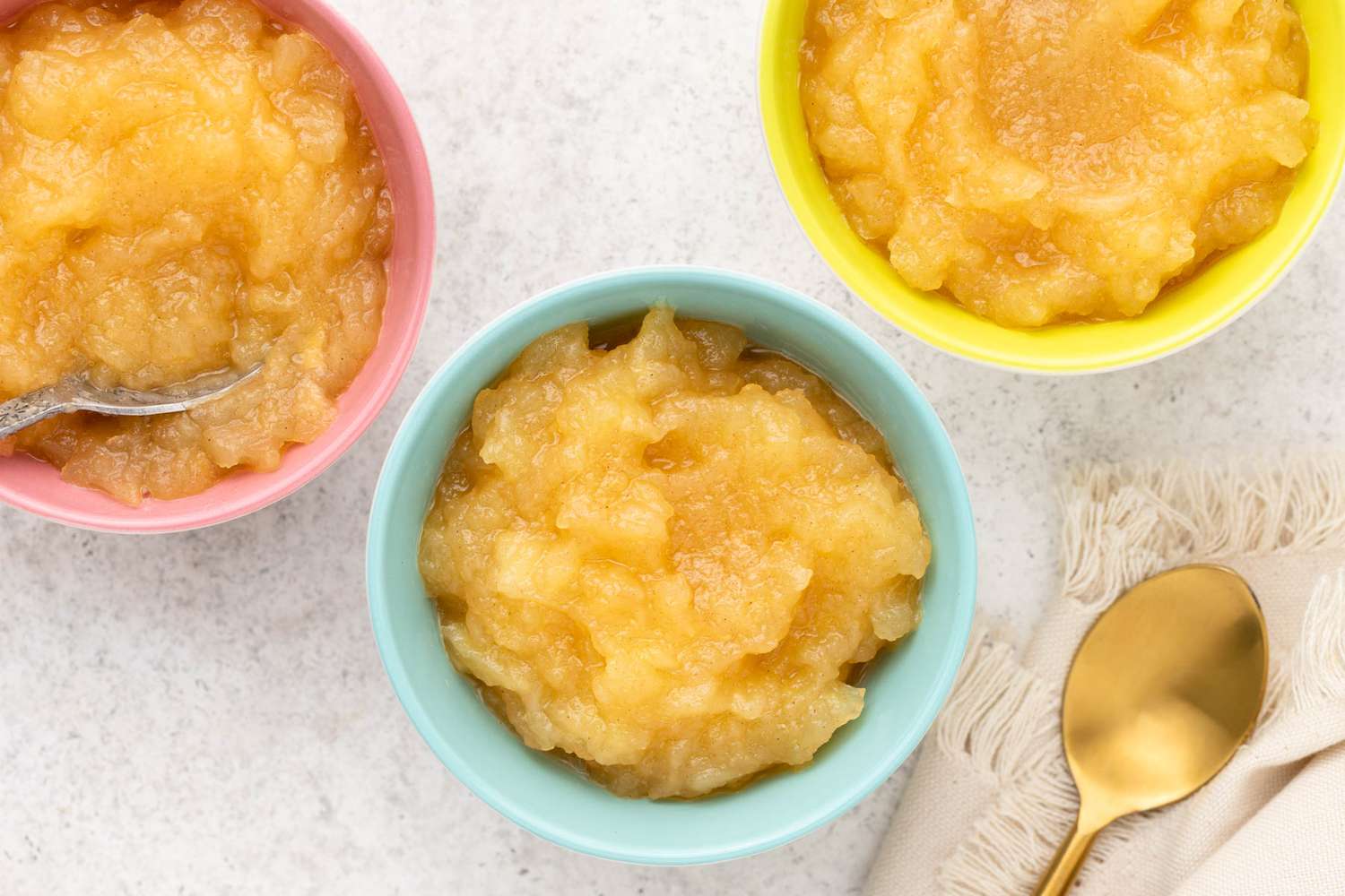 small bowls with Microwave Applesauce in them, spoon and napkin on the side