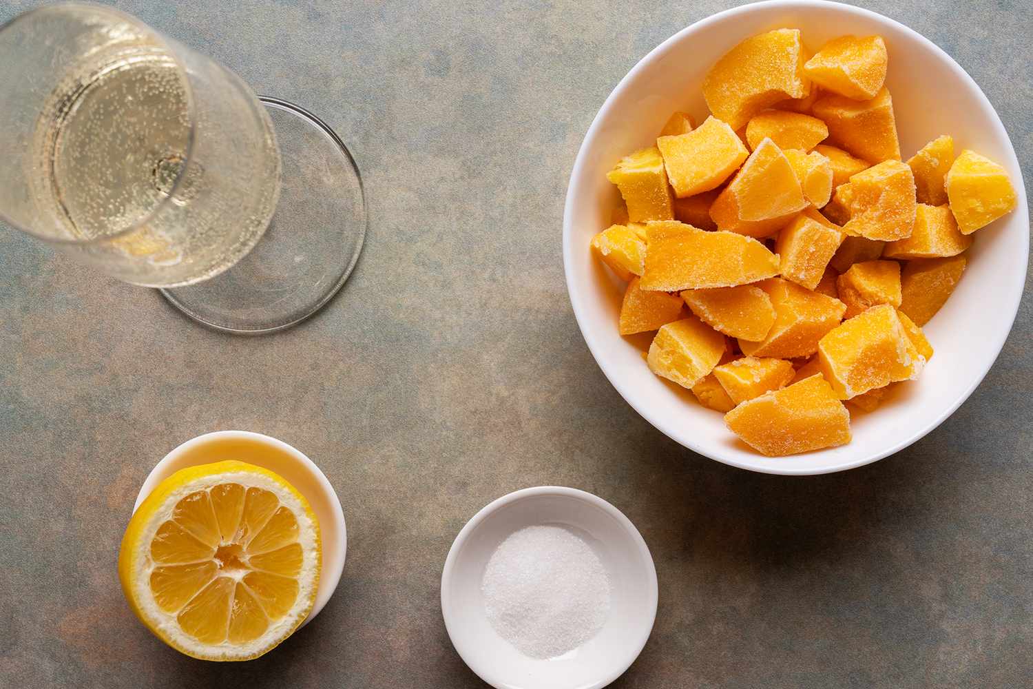 Frozen peaches in a bowl with a glass lemon slice and sugar bowl
