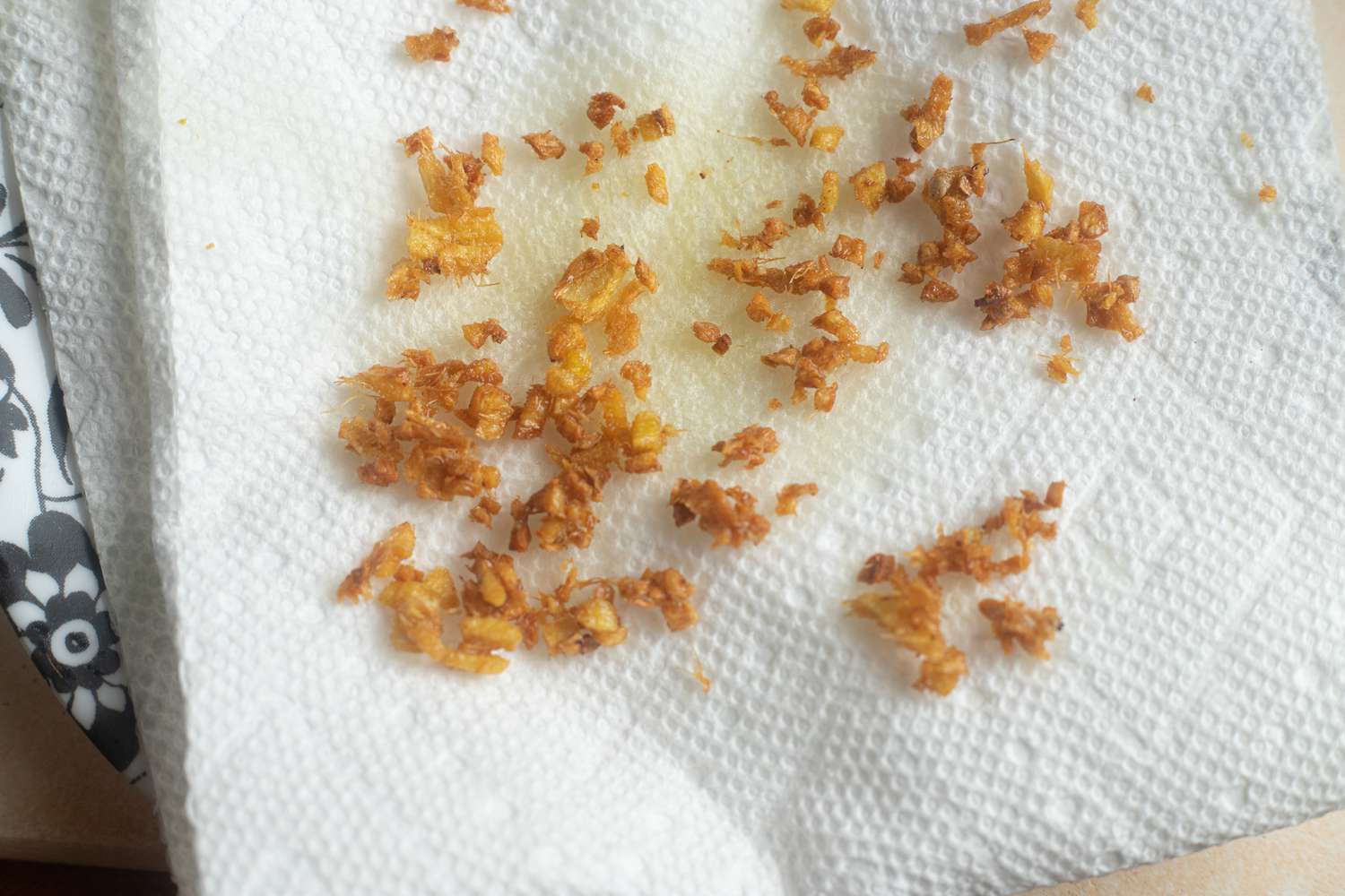 Fried ginger topping draining on paper towels to make a fish poached in coconut with ginger and lime recipe