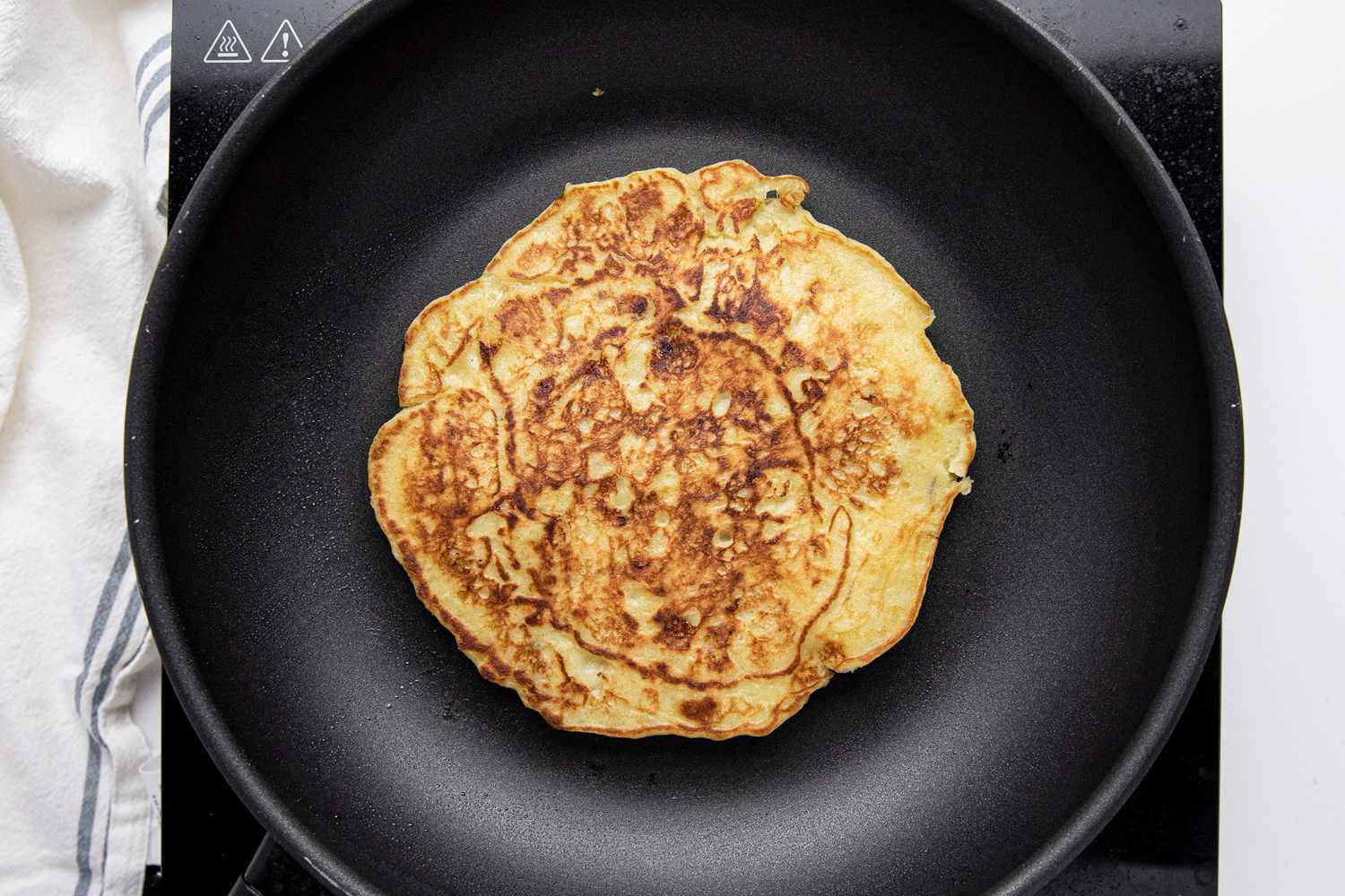On a Skillet, a 3-Ingredient Banana Pancake Flipped with Cooked Side Facing Upwards