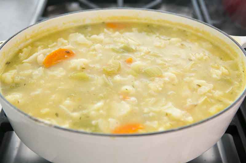 Pureed vegetables for cauliflower cheese soup cooking in pot
