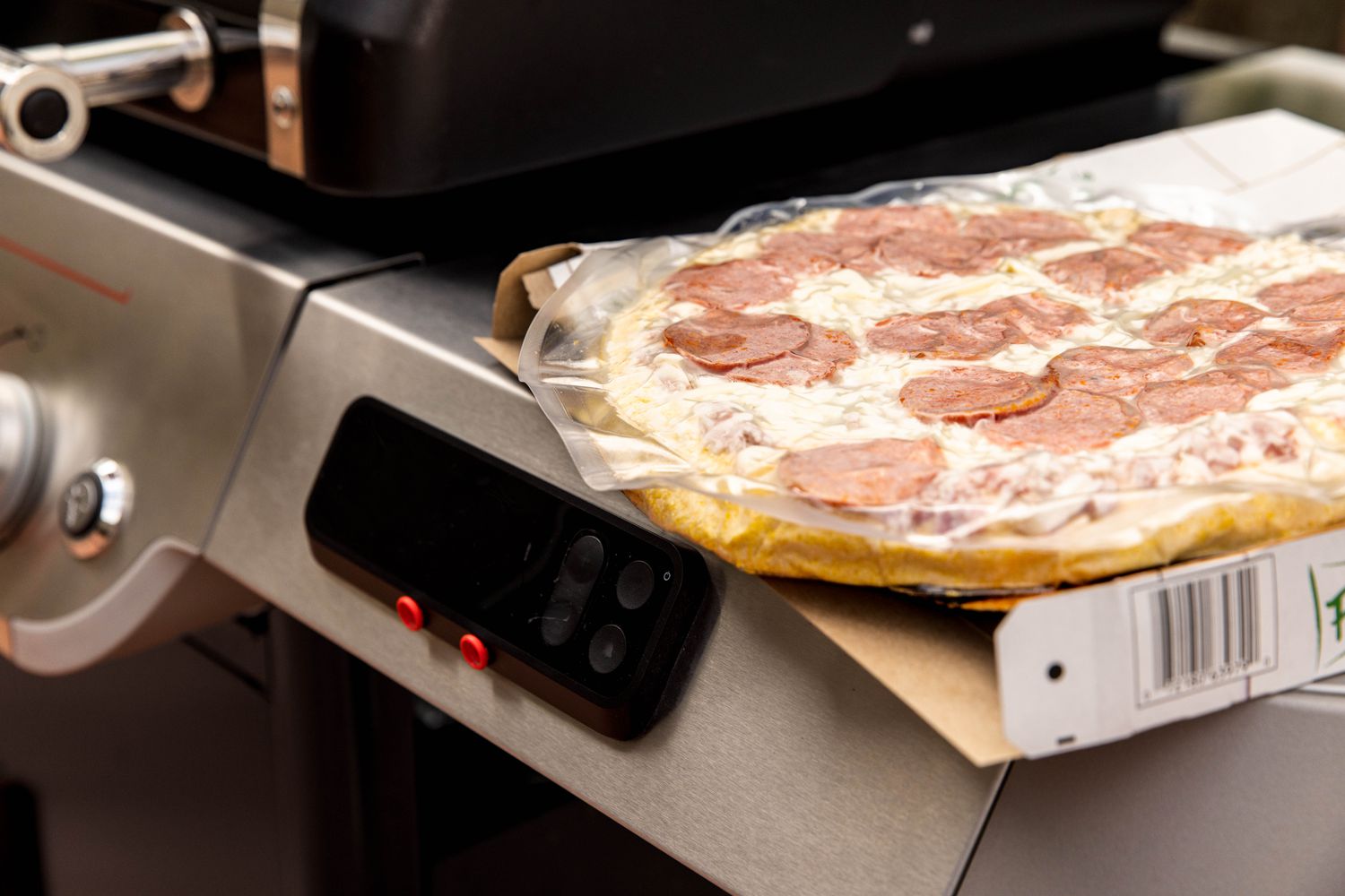 package of frozen pizza by the grill