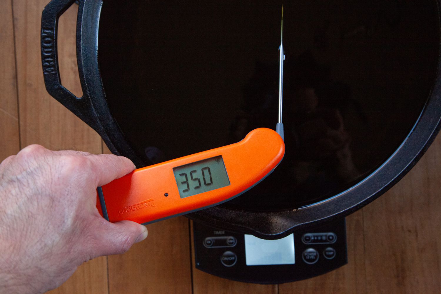 An instant read thermometer showing the temperature of frying oil for Nashville-style hot chicken.