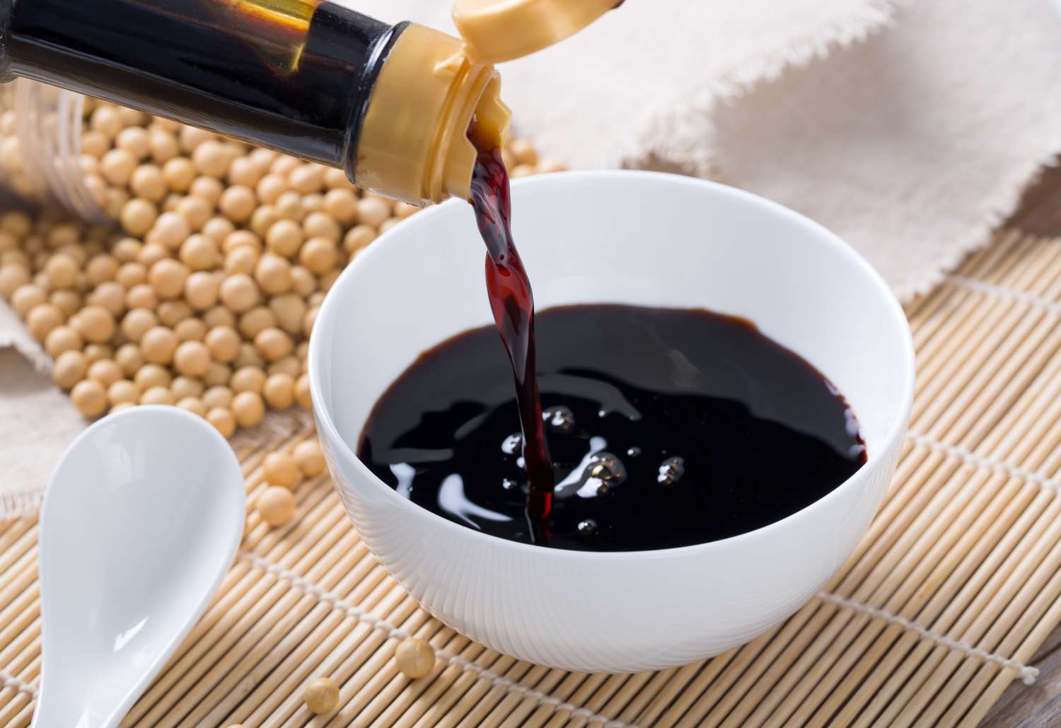 Soy sauce being poured into a white bowl